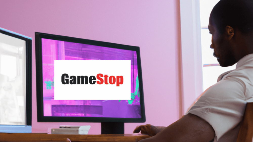 一个男人坐在电脑前浏览 gamestop 网站的图片