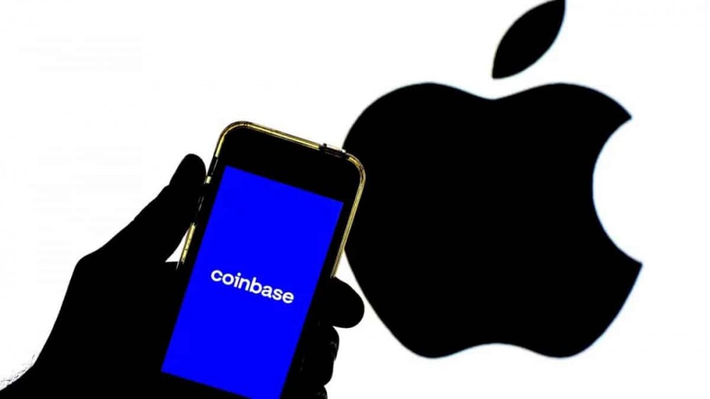 打开Coinbase App的手机图片，背景是苹果公司标志的剪影
