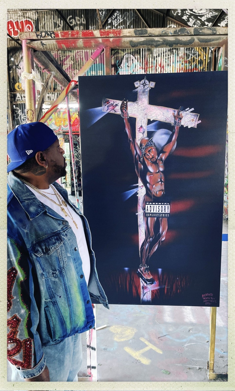 Riskie Forever 的图片在他的原创 Tupac 艺术品旁边。